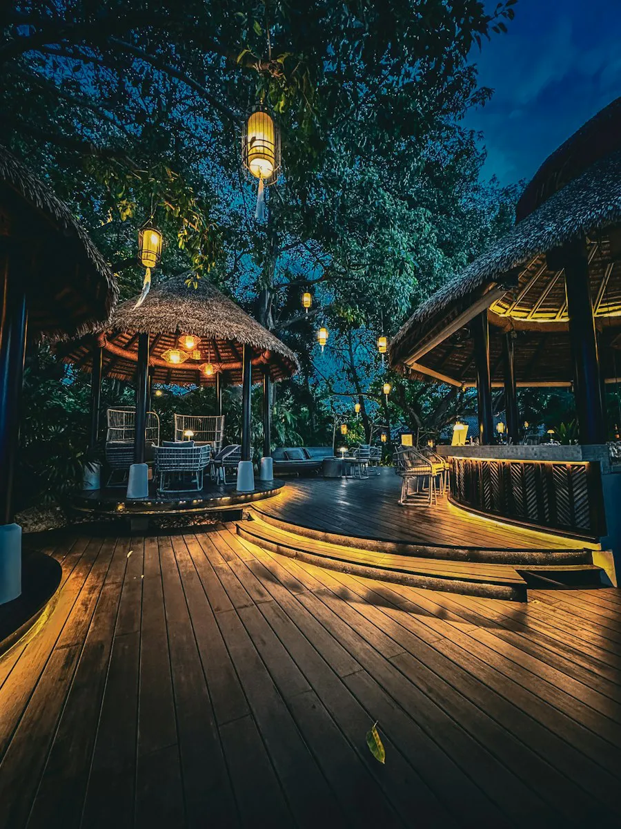 Resort with lit wooden gazebos and decks at night